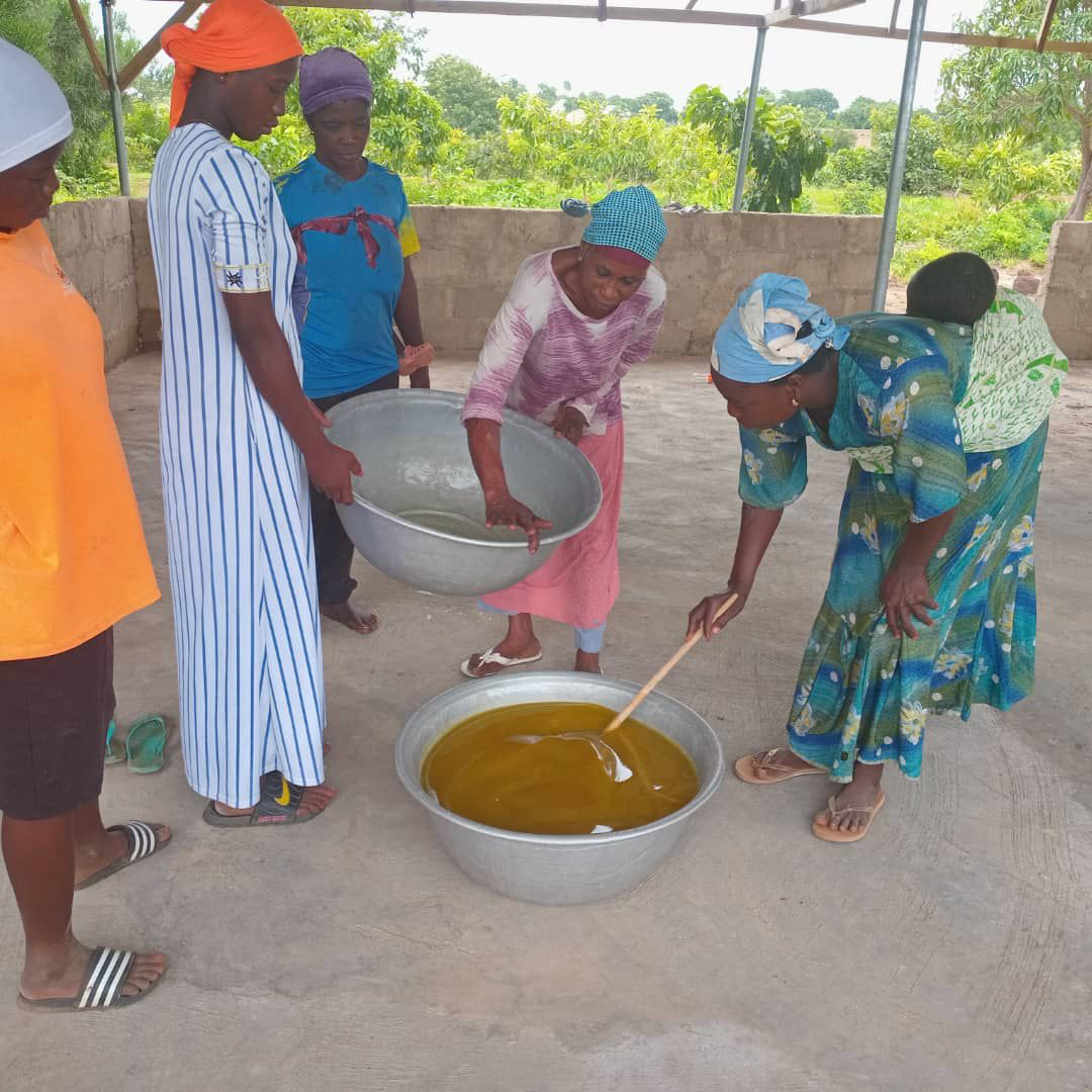 Women stirring shea butter during processing training