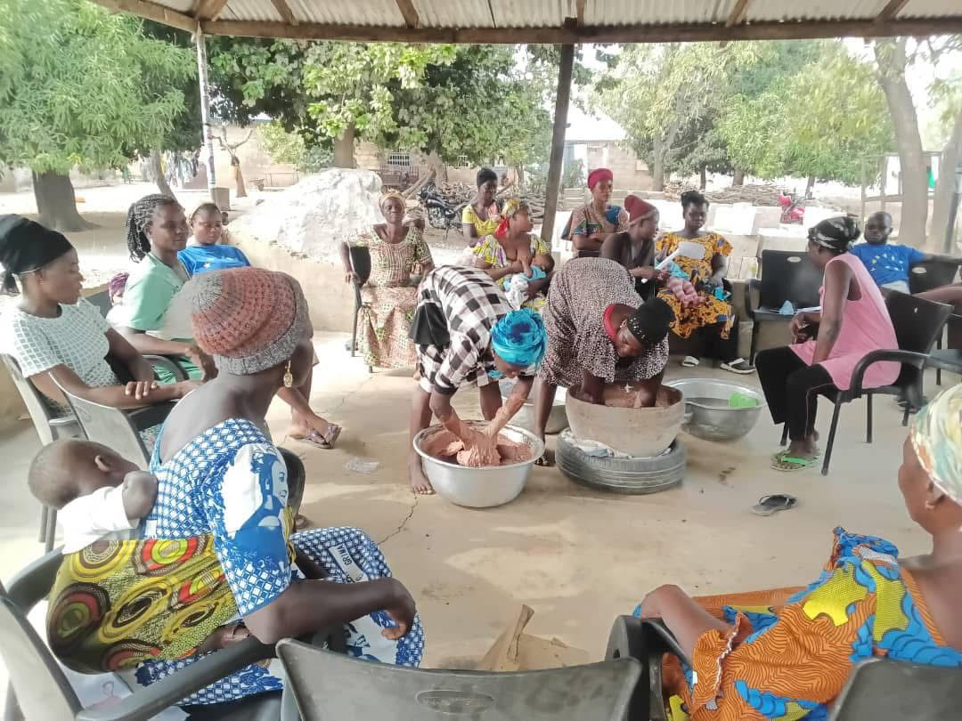 Community women learning shea nut grinding techniques